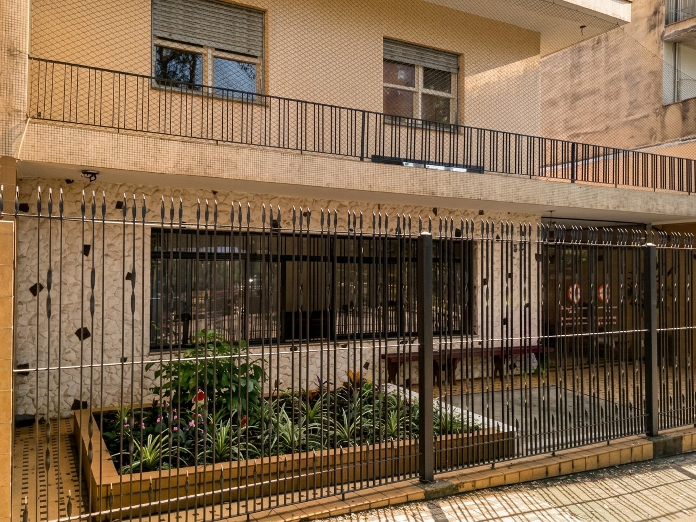 Frente da casa, com gradil e canteiro de plantas